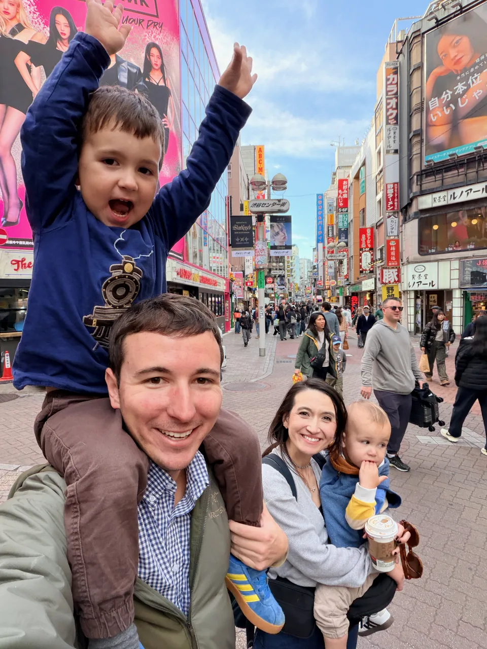 A family of four exploring a bustling shopping street